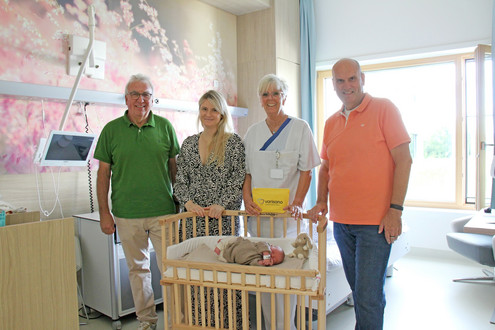 Elke Simmons, Stationsleiterin der Geburtenstation am varisano Klinikum Frankfurt Höchst (3.v.l.), freut sich über die erneute Bettchenspende vom Förderkreis des Klinikums, die Vereinsvorsitzender Uwe Serke und sein Stellvertreter Dr. med. Harald Hake kürzlich übergab.