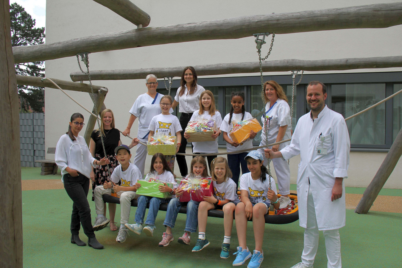 Gruppenfoto mit Schülern der Viktoria Luise Schule und dem Team der Kinderklinik Höchst auf dem Outdoorspielplatz an Gebäude A